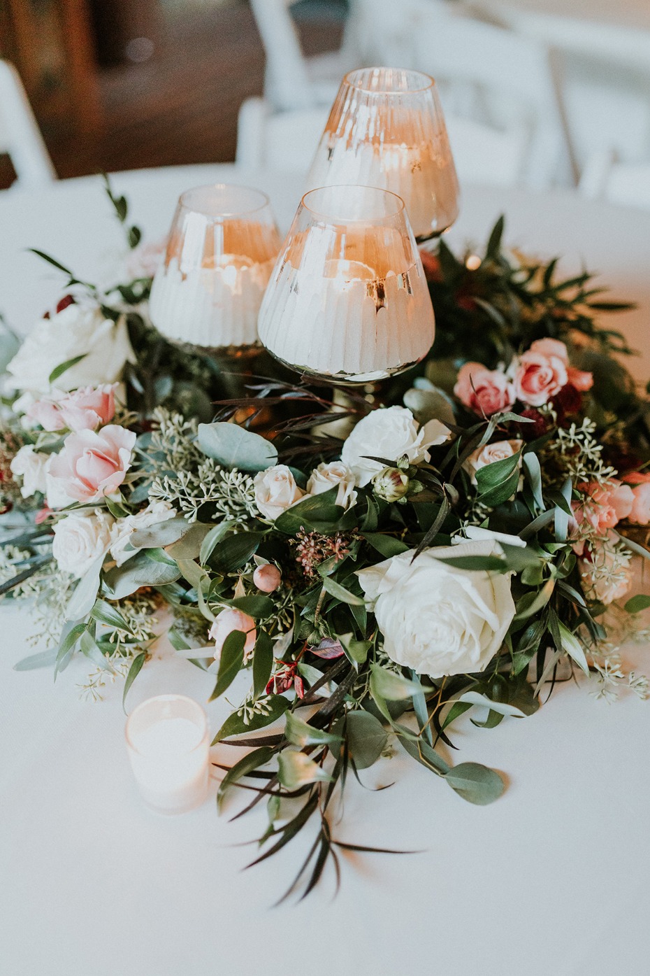 Romantic floral centerpiece with glowing table candles
