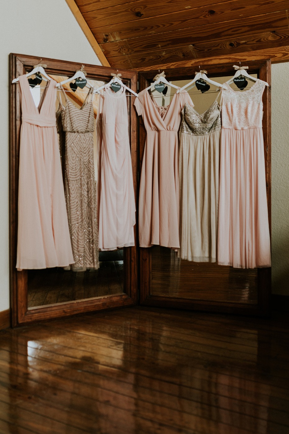 Bridal party dresses hanging in a mirrored doorway
