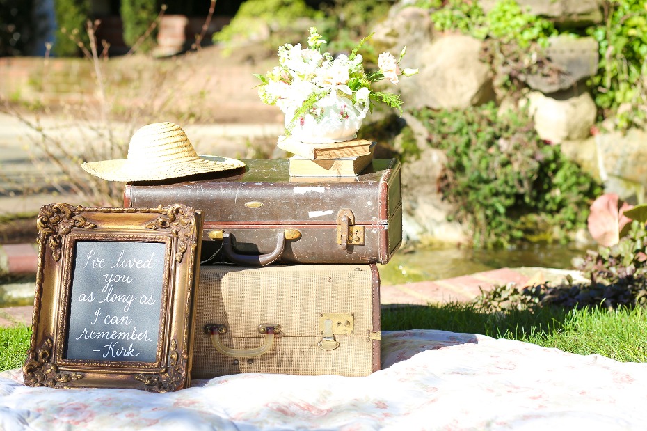 Vintage suitcases floral arrangement and framed quote outdoors
