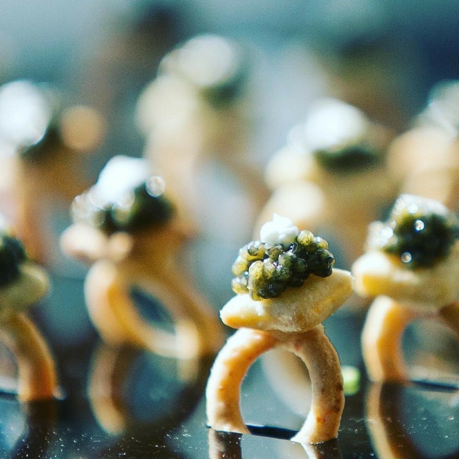 Close up of caviar appetizer rings on reflective surface