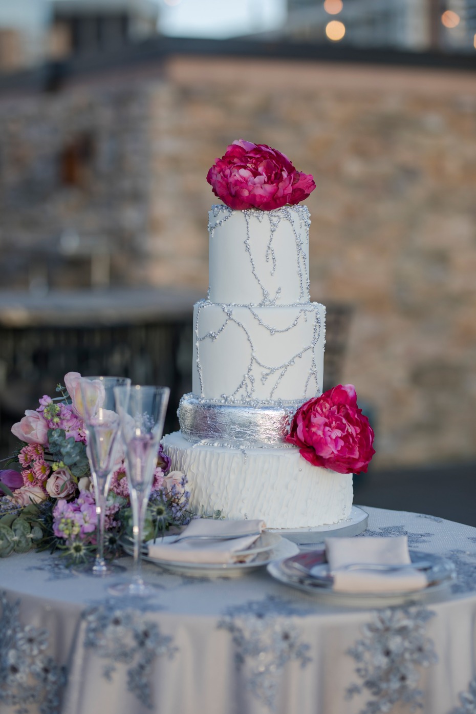flower topped wedding cake with silver accents