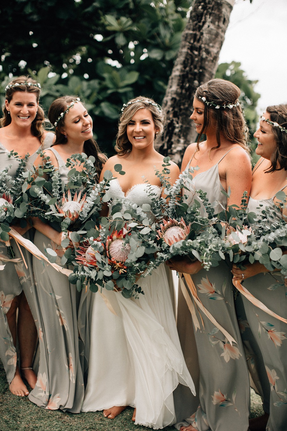 Bride and bridesmaids with protea bouquets outdoors