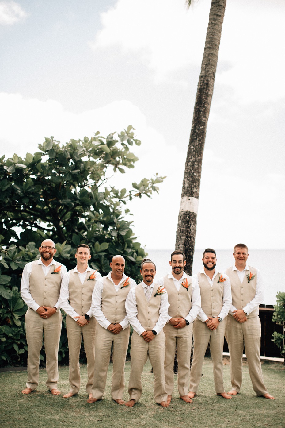 Groomsmen in beige suits at tropical beach wedding