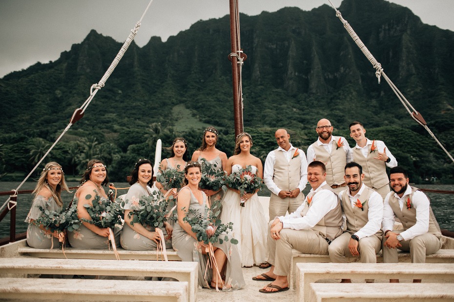 Hawaii wedding party on a boat with mountain backdrop