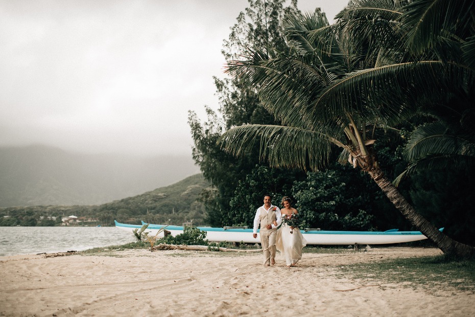 Bride and groom walk on a tropical beach after wedding
