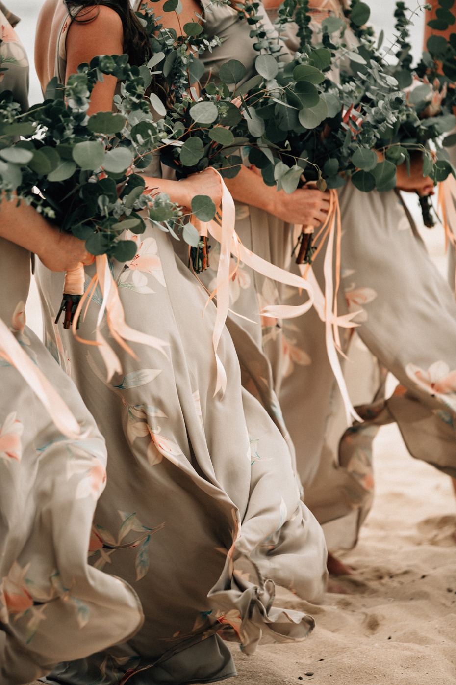 Bridesmaids in flowing dresses with eucalyptus bouquets