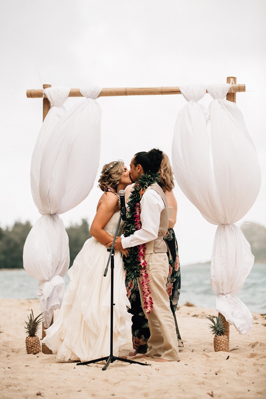 Bride and groom kissing at their beach wedding ceremony