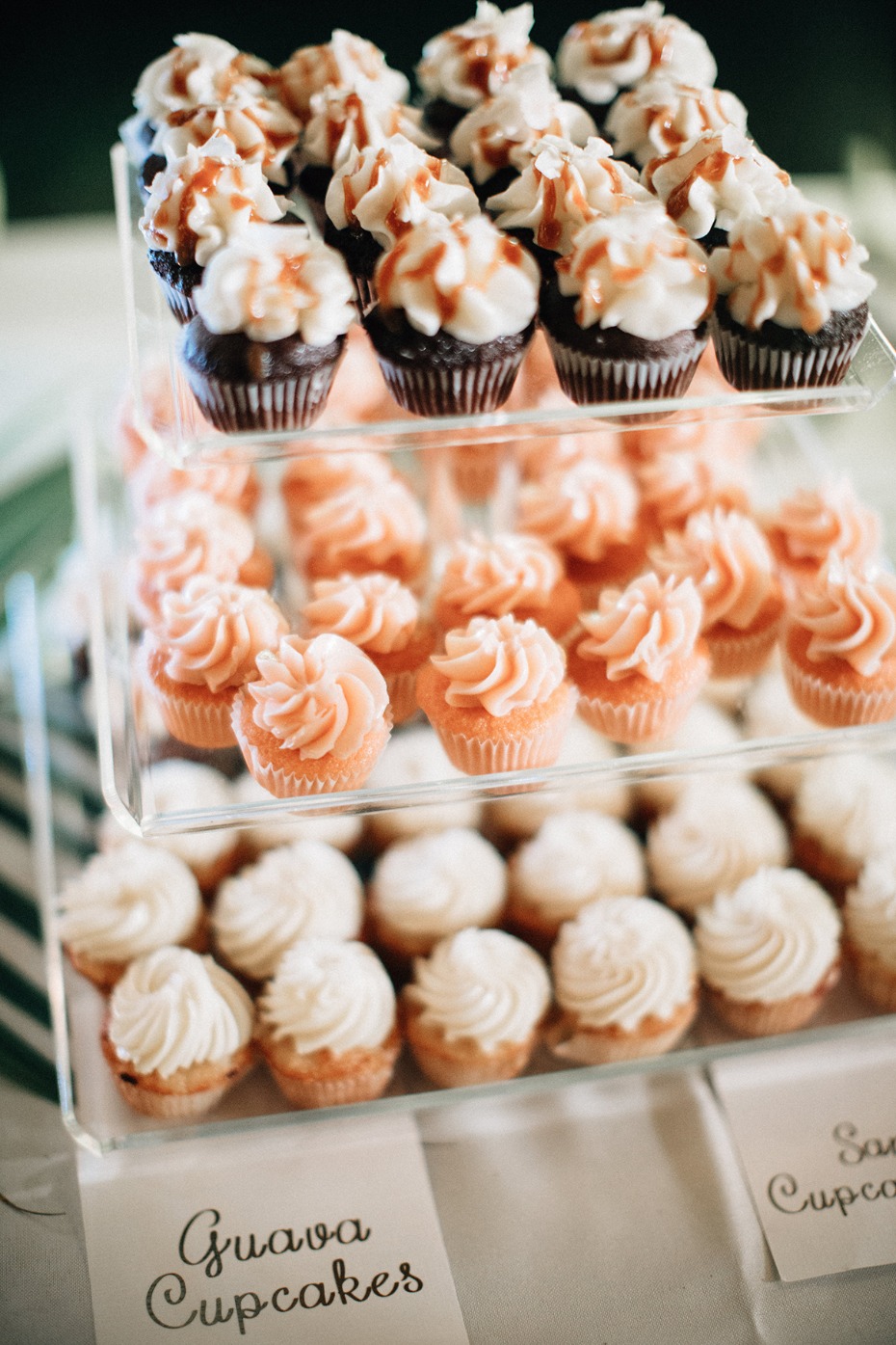 Three tiered display of mini cupcakes with varied flavors