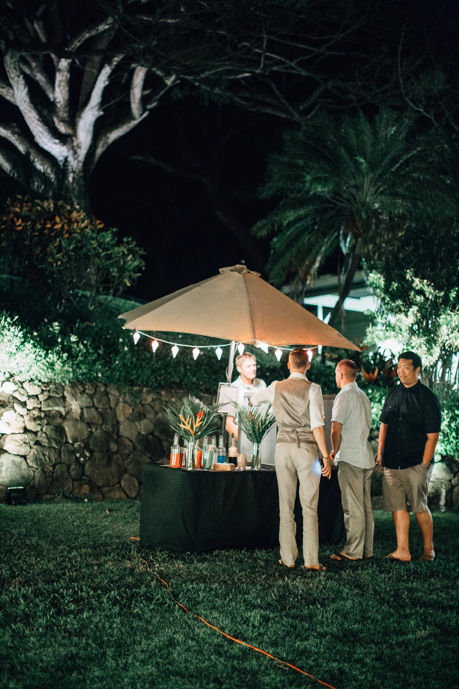 Outdoor bar at nighttime gathering with guests waiting
