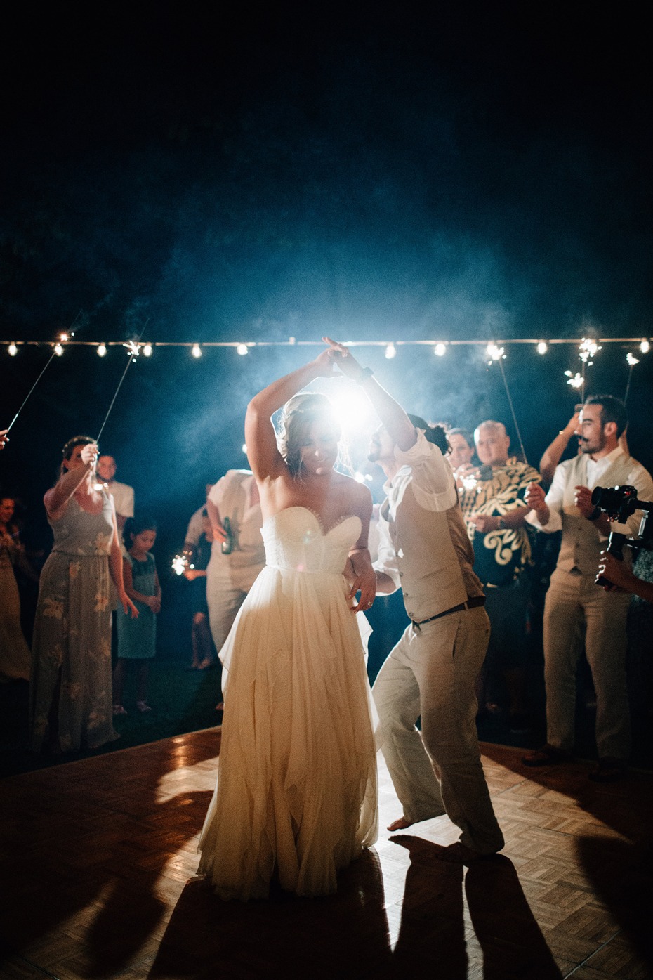 Bride and groom dancing under string lights at their wedding