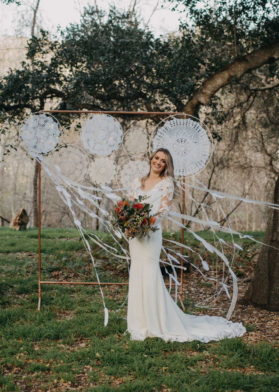 Bride in lace dress with boho dreamcatcher backdrop
