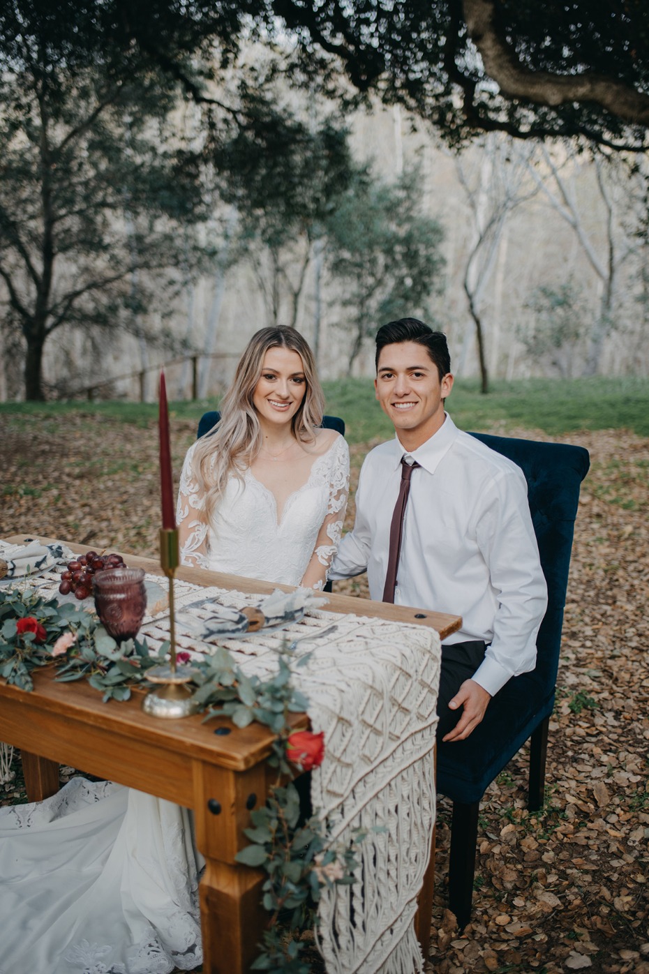 Bride and groom at rustic outdoor wedding table