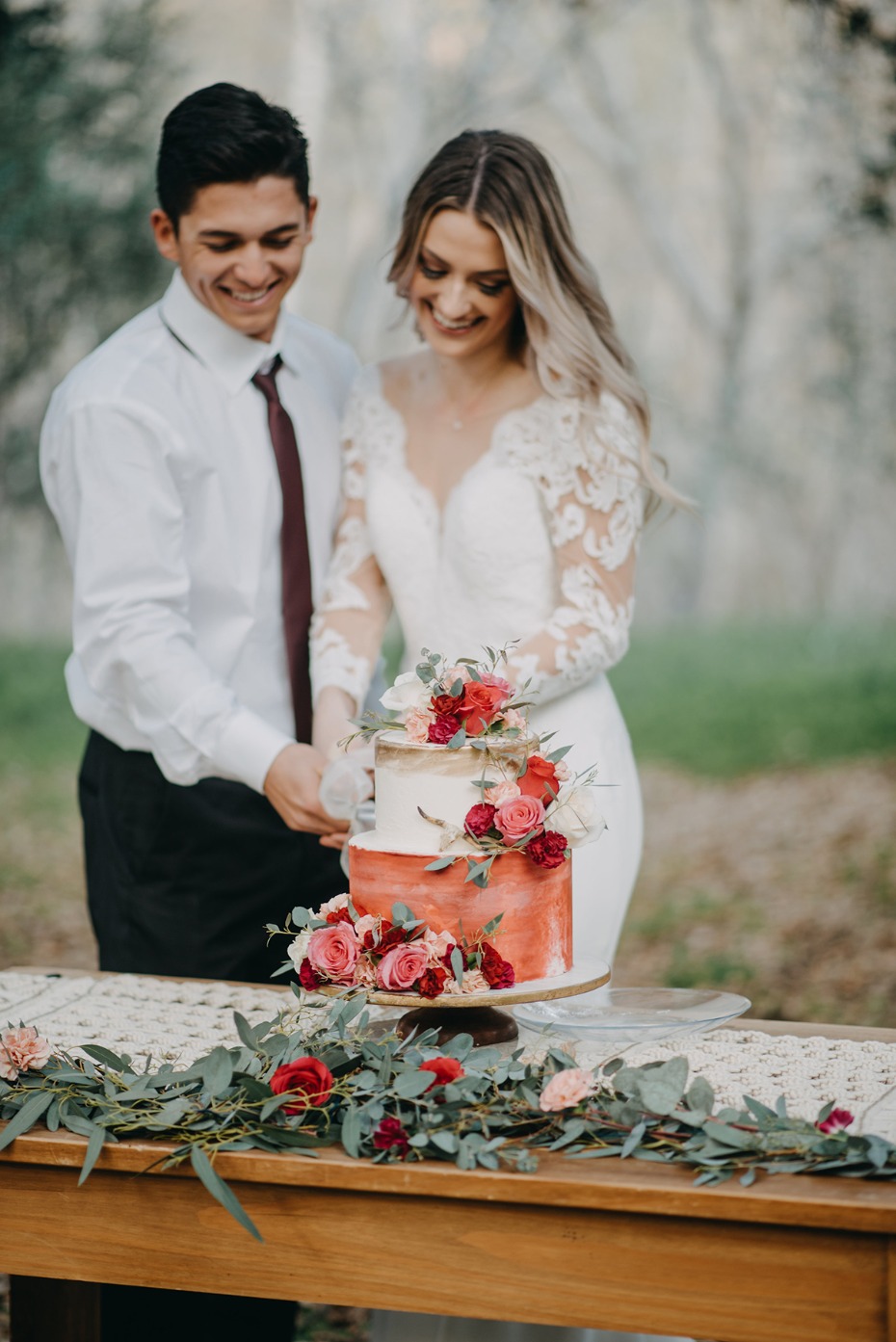 Bride and groom cut their flower decorated wedding cake