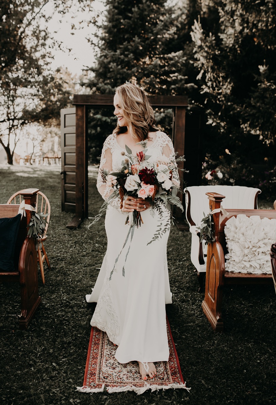 Smiling bride walks aisle in outdoor wedding ceremony
