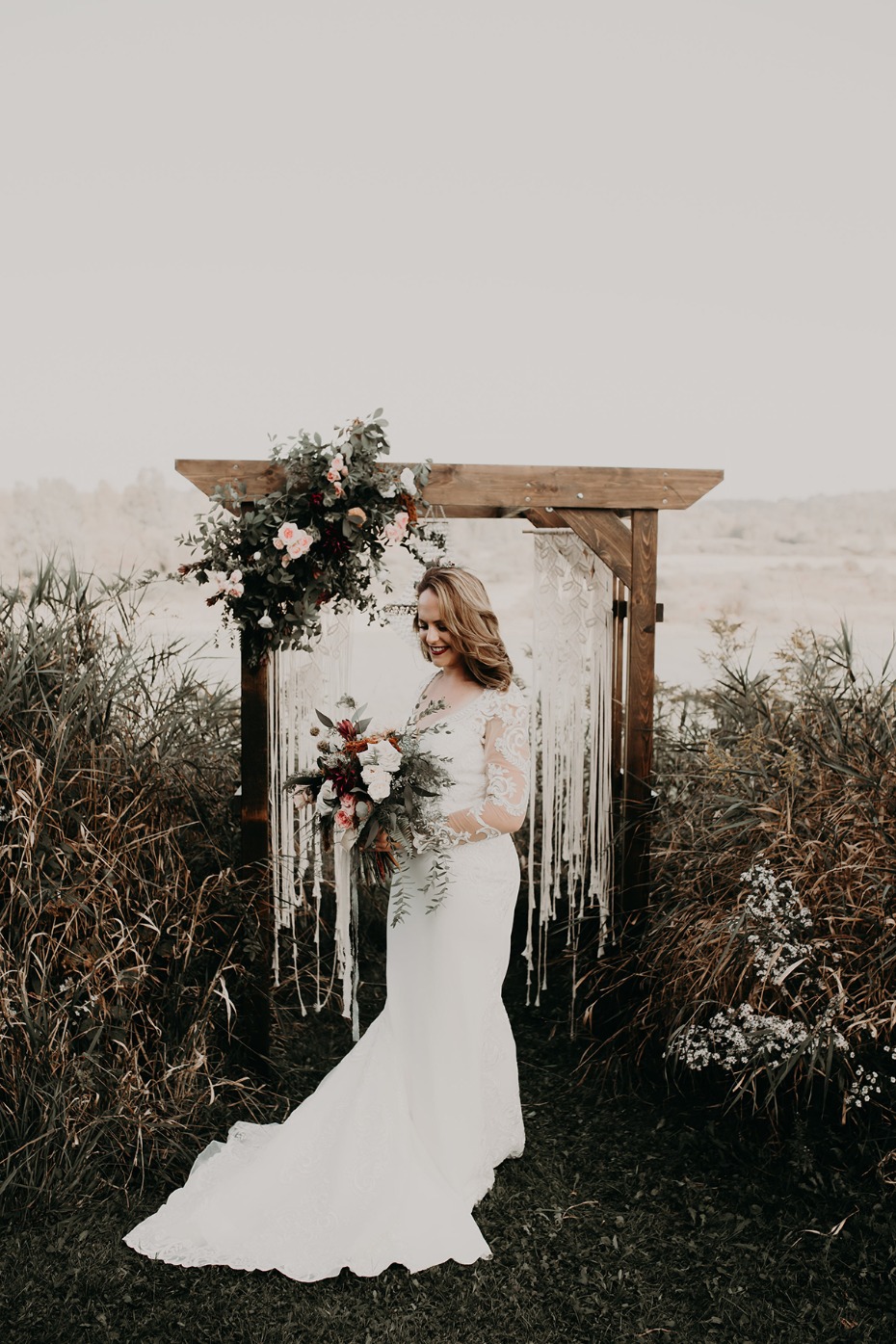 bride in front of a macrame wedding backdrop