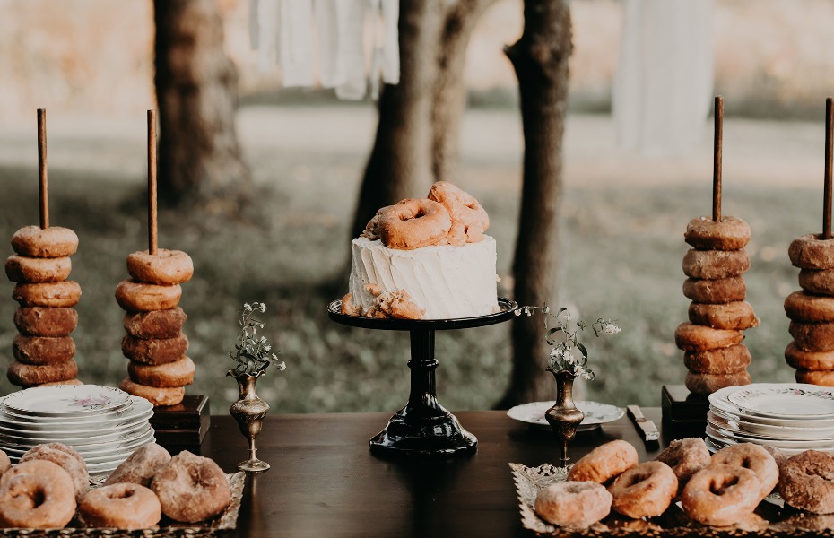 Charming outdoor dessert table full of delicious donuts