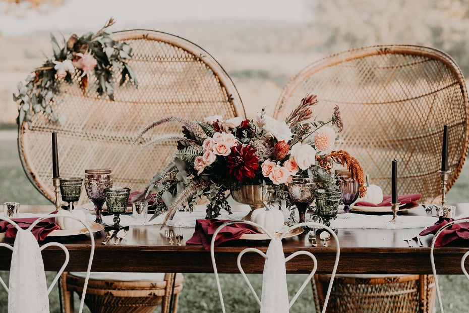Elegant wedding table with flowers and wicker chairs