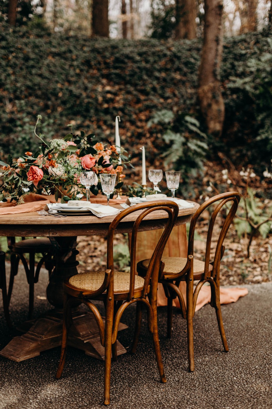 Outdoor wedding table setting with floral decor and chairs