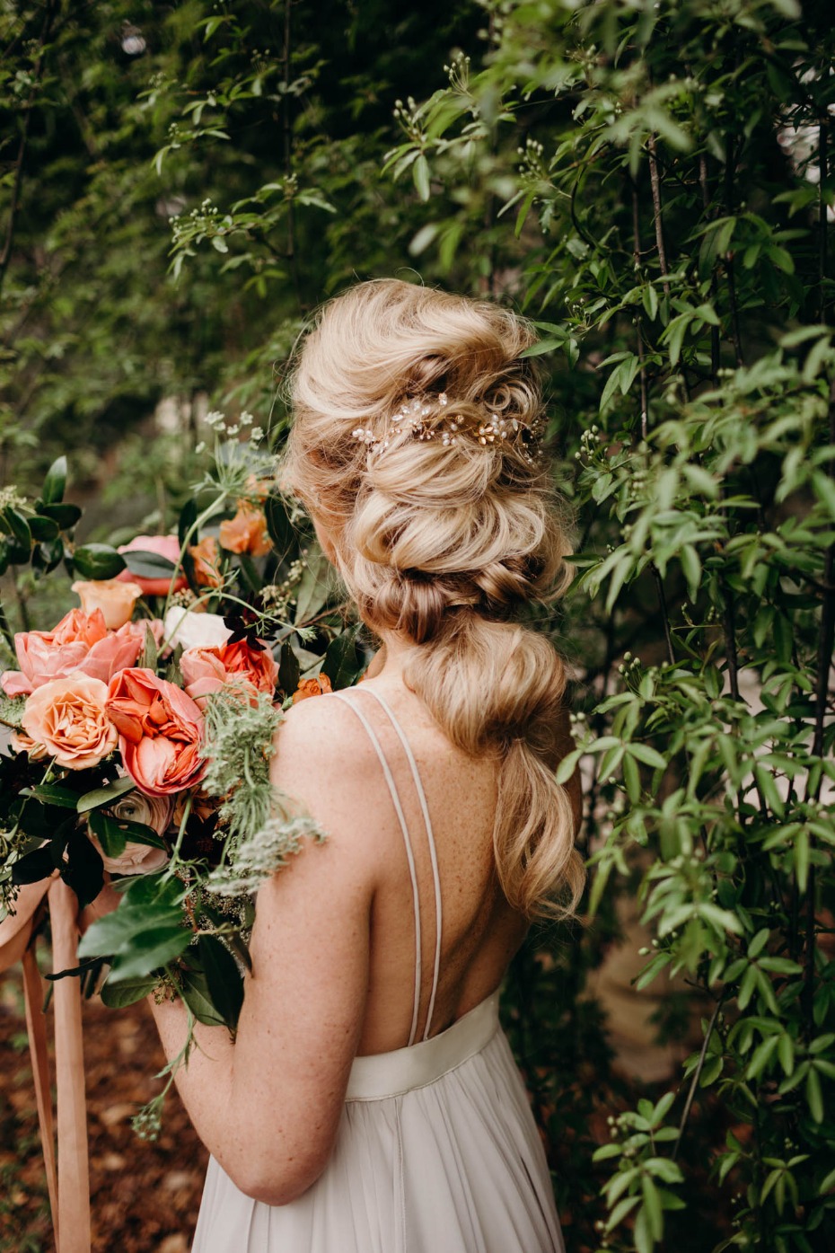 Blonde bride with flowers and braided updo hairstyle