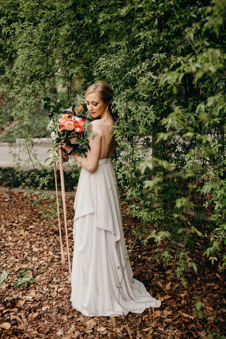 Bride in garden with bouquet elegant wedding dress
