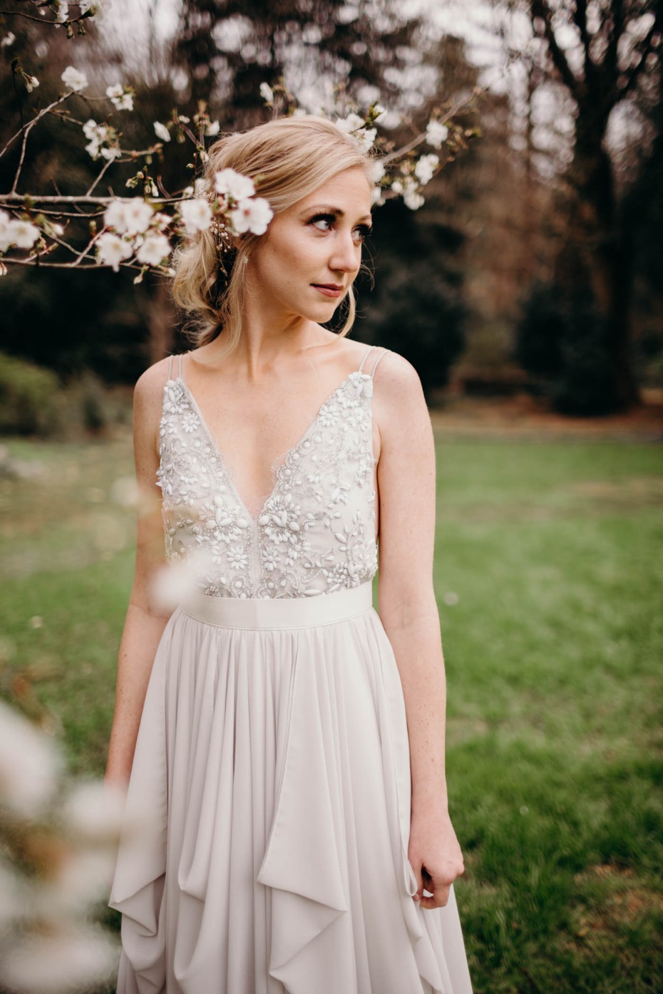 Bride in flowing gown with floral hair piece outdoors