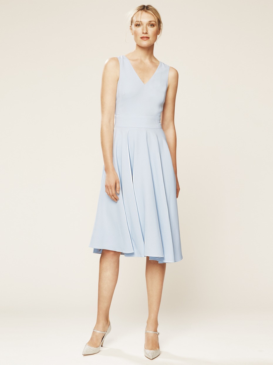 Woman in light blue V neck midi dress with silver heels
