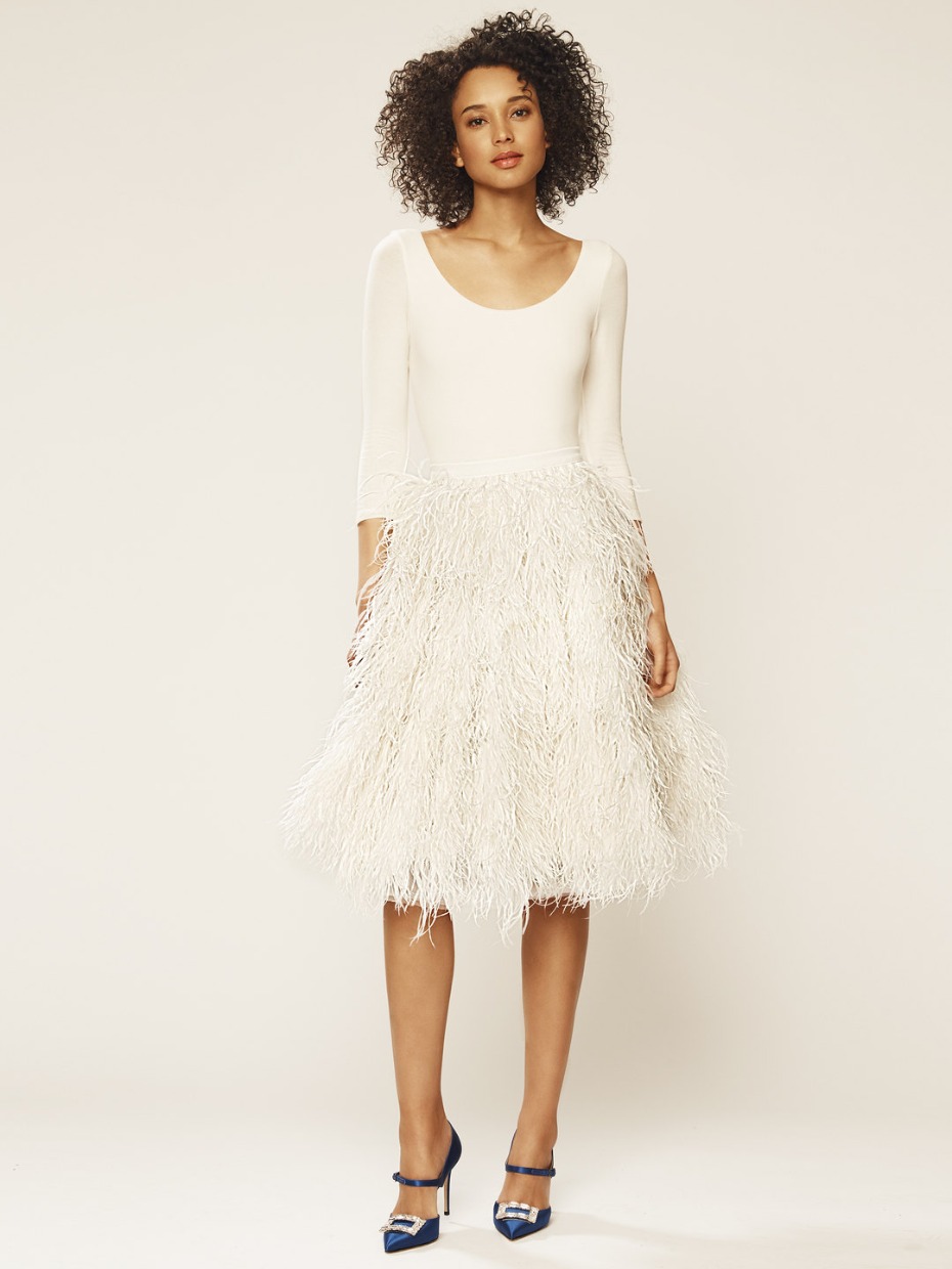 Woman in chic dress with feather skirt and blue heels
