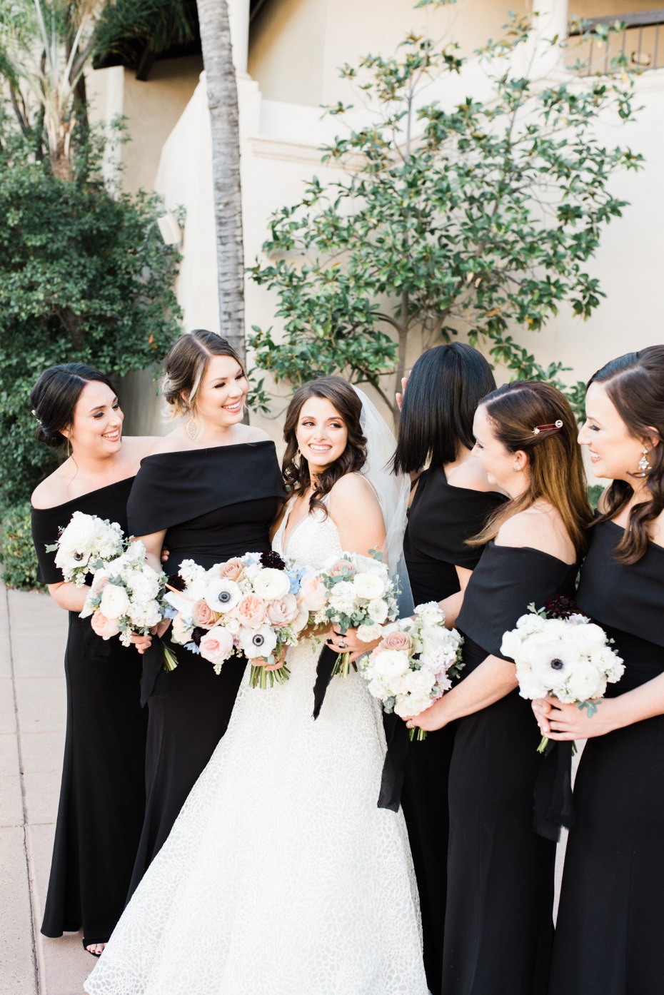 Bride with bridesmaids in black dresses and bouquets