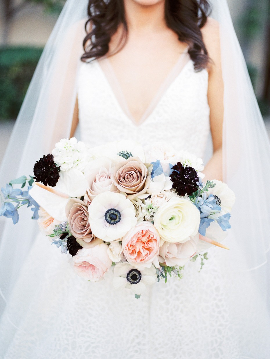 Bride holding a stunning bouquet of white and blush flowers on her wedding