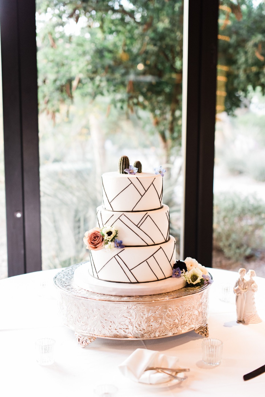 Elegant wedding cake with geometric design and cactus toppers
