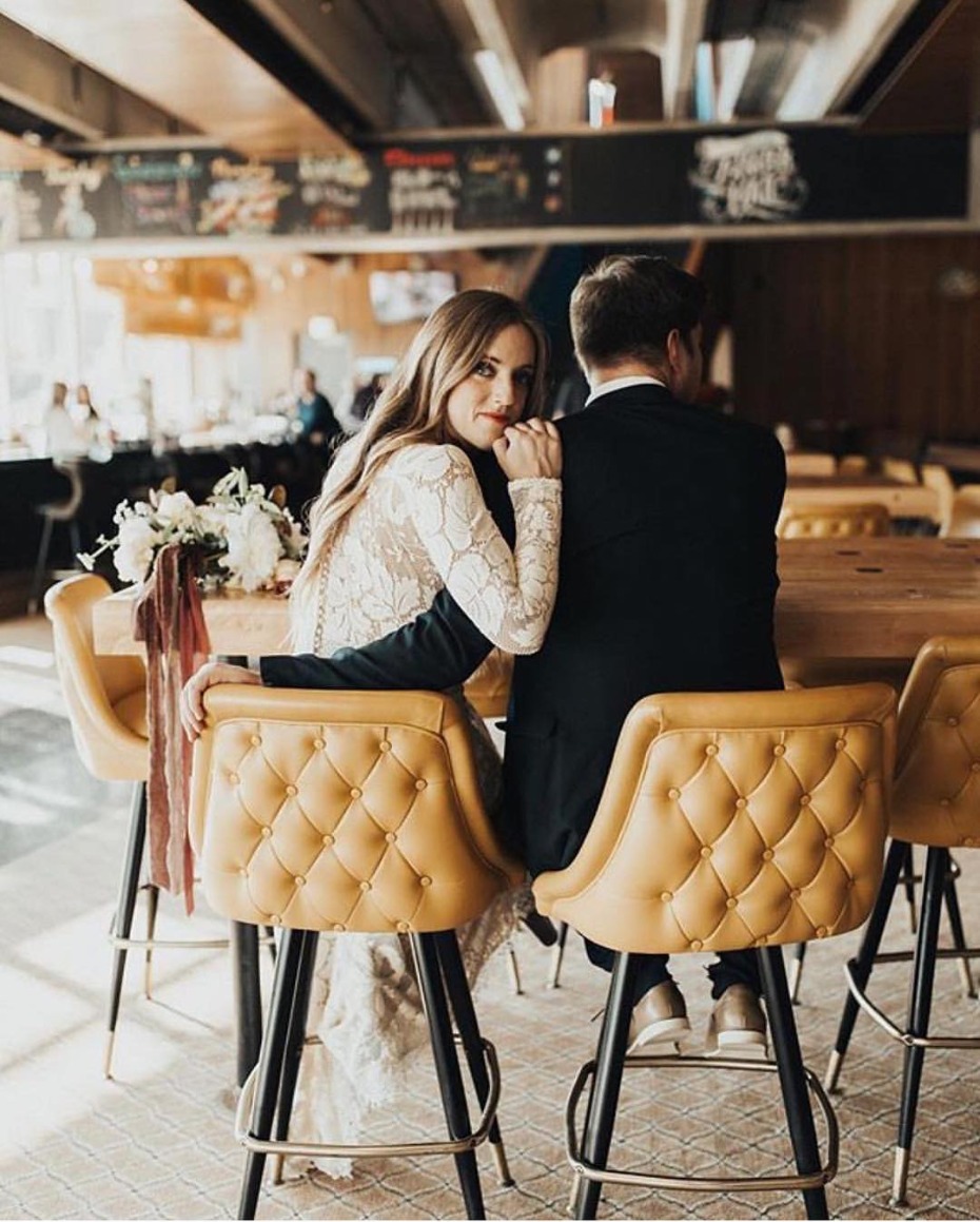 Bride and groom smiling together, embracing at a bar wedding