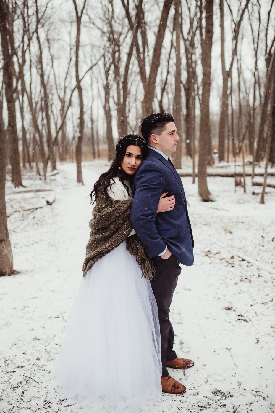 Elegant couple in winter wedding photos in a snowy forest
