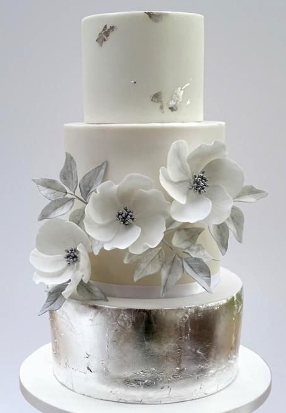 white and silver wedding cake with anemones flower