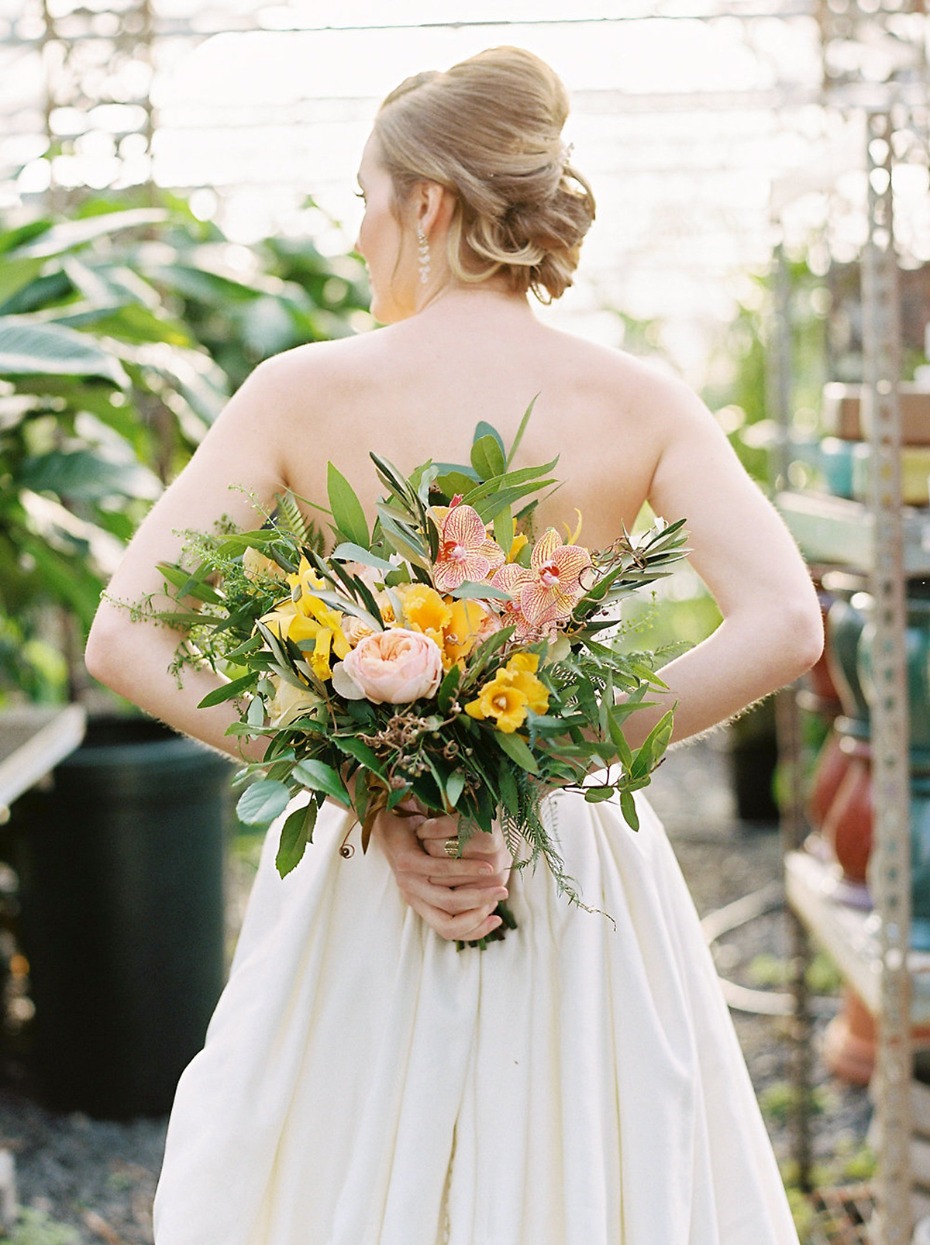 Bride holds a vibrant flower bouquet behind her back