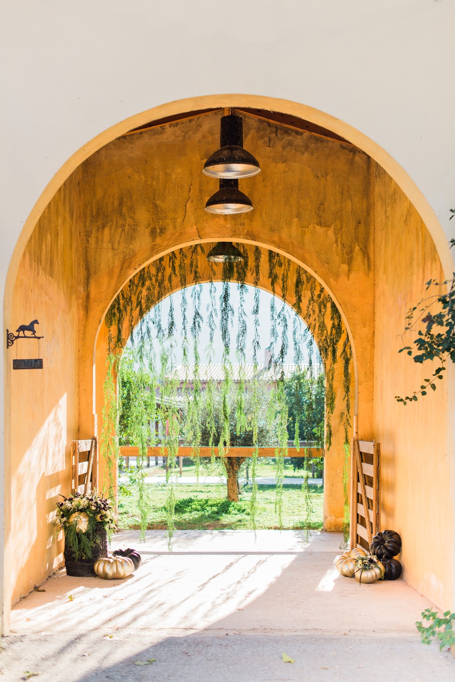 Arched walkway decorated with flowers and pumpkins