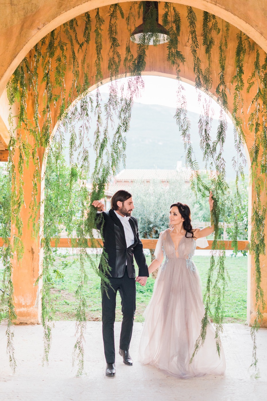 Bride and groom under floral archway wedding photo