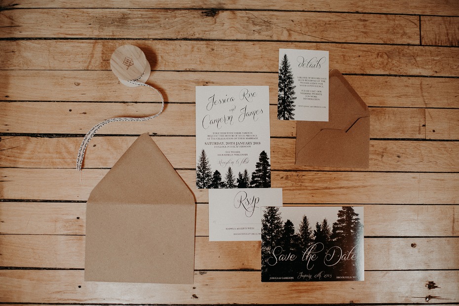 Wedding invitation suite with a forest theme on a wooden table