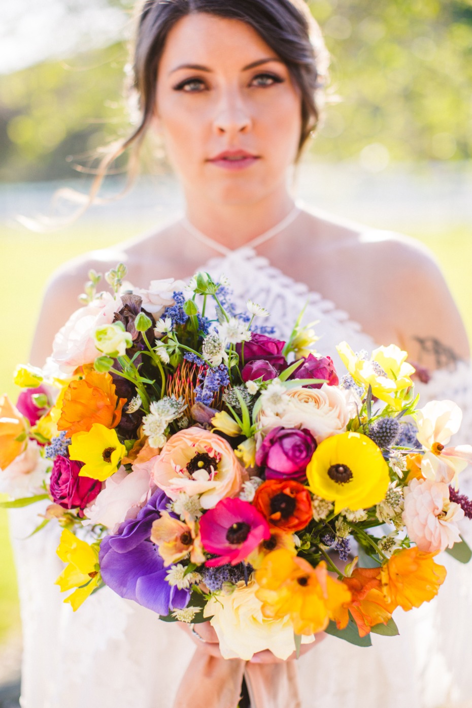 Bride with bright floral bouquet at outdoor wedding