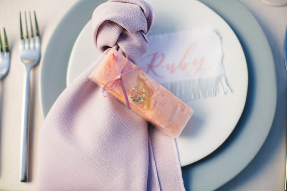 Pink favor tied with ribbon on lavender napkin, for Ruby