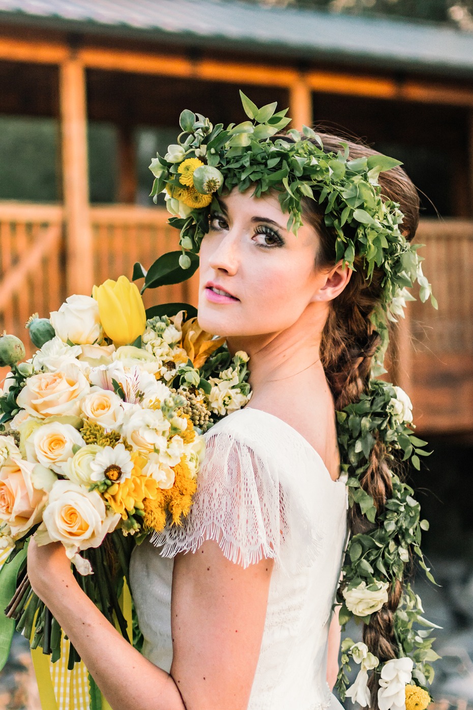 Bride with flower crown and cascading braid holding bouquet