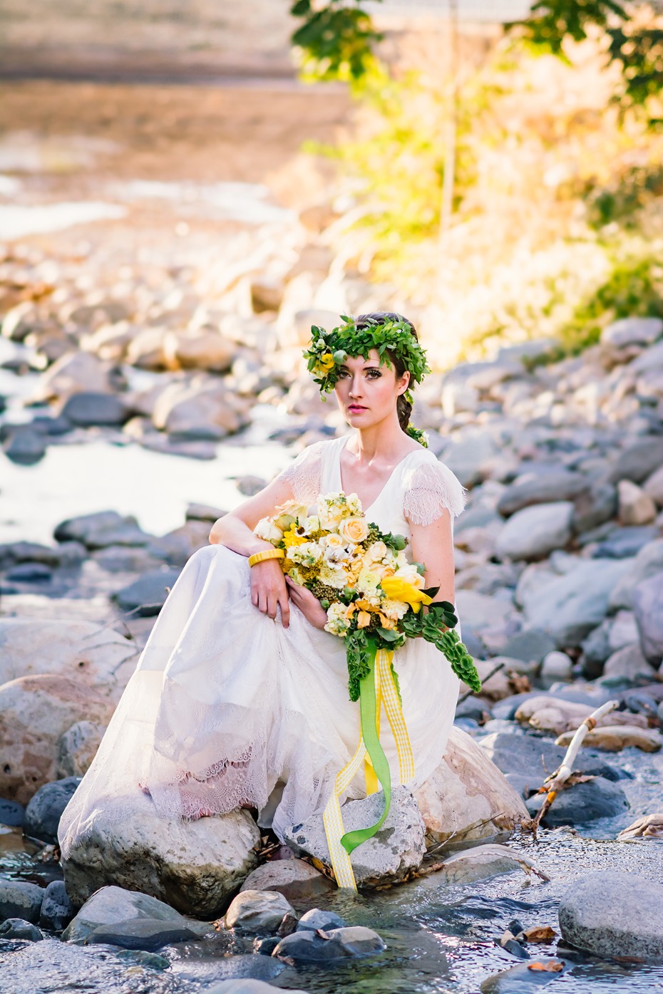 Bride with flower crown and bouquet by the river bank