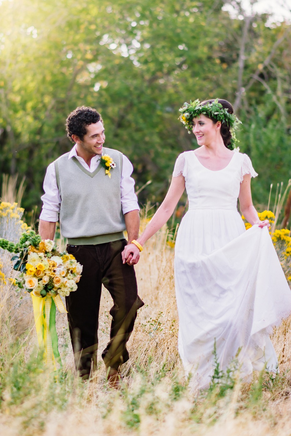 Rustic wedding couple holding hands in a field of wildflowers