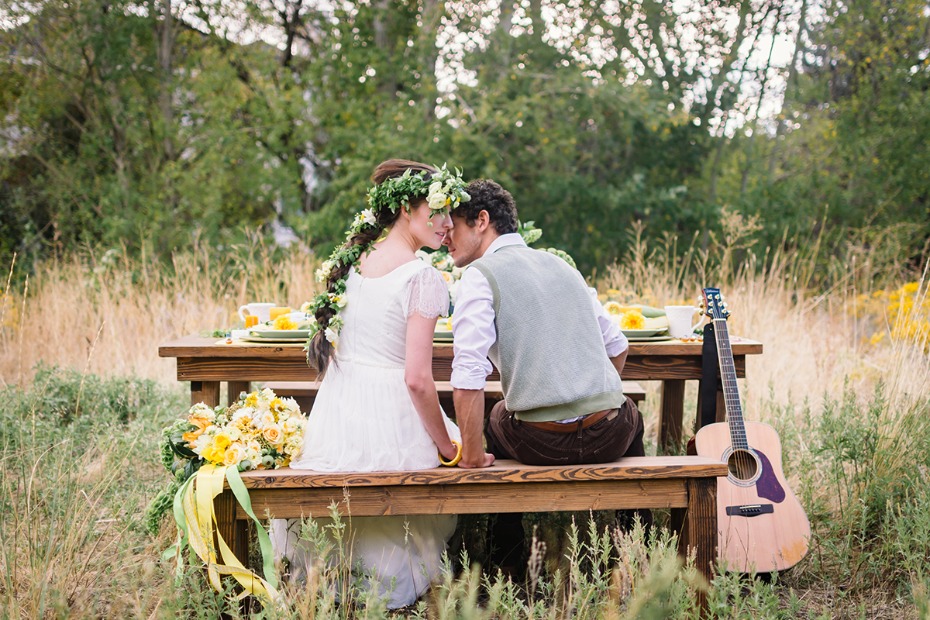 Boho wedding couple kisses at outdoor rustic reception