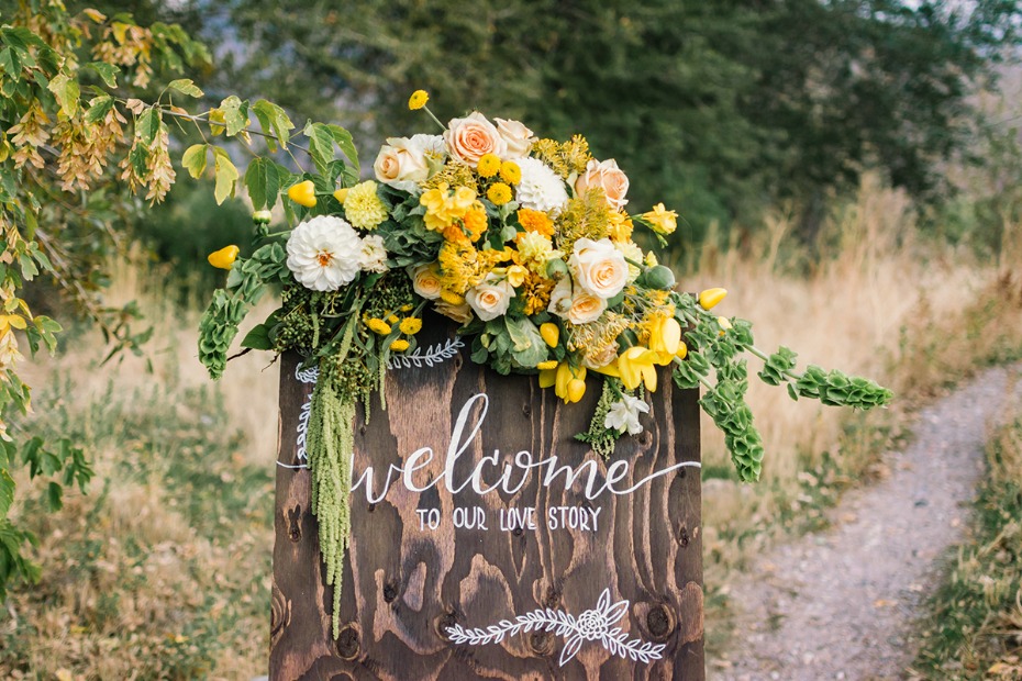 Welcome sign with yellow flowers at outdoor wedding