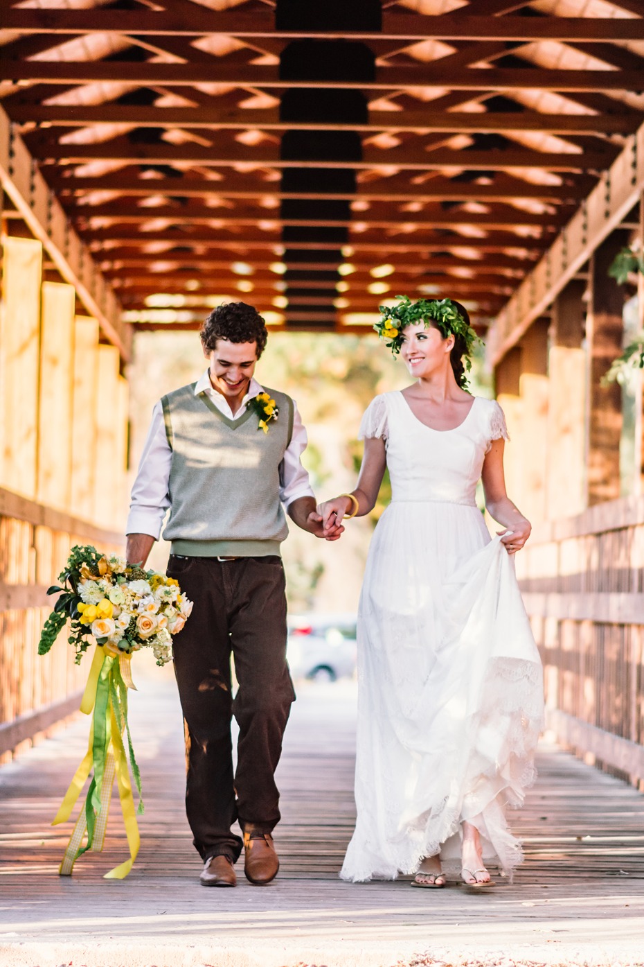 Happy rustic bride and groom walking on a wooden bridge