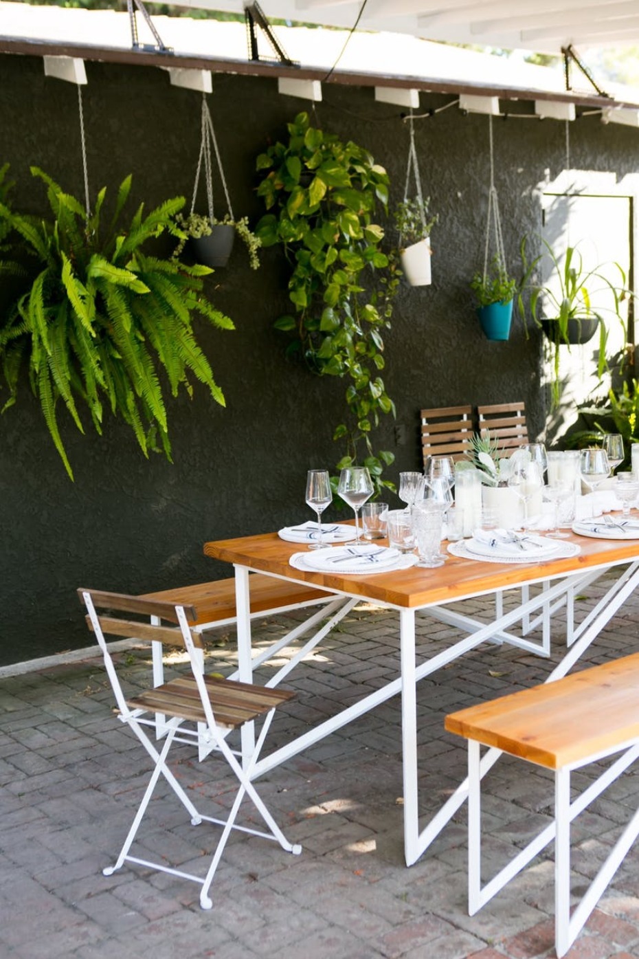 Outdoor dining area with hanging plants and wooden table