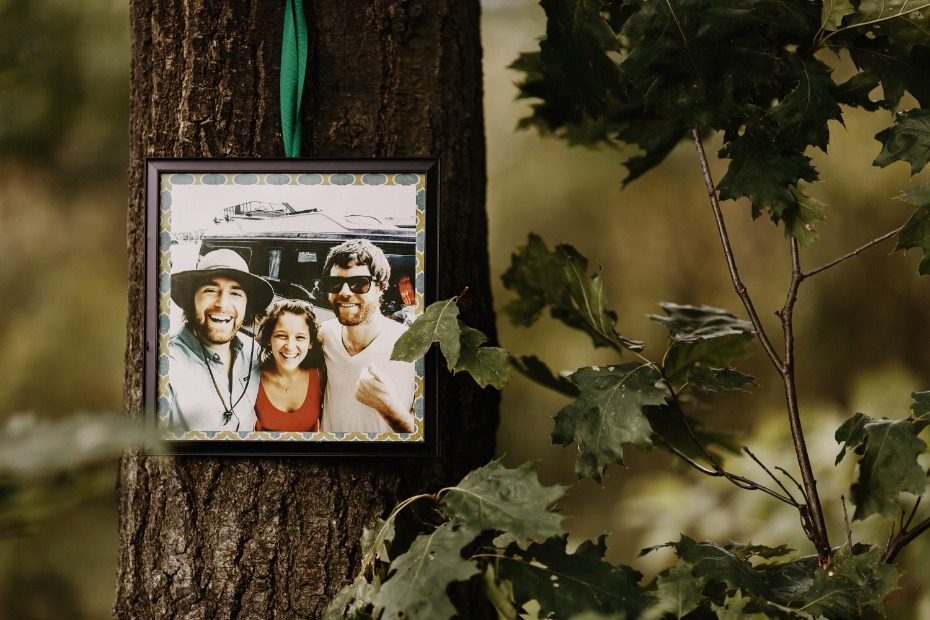 Framed photo of three smiling friends on a tree trunk