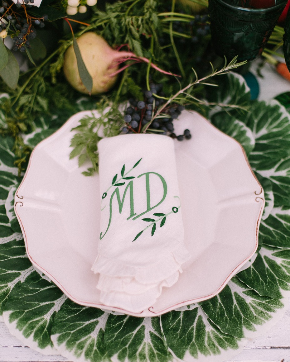 Elegant place setting with monogrammed napkin and greenery
