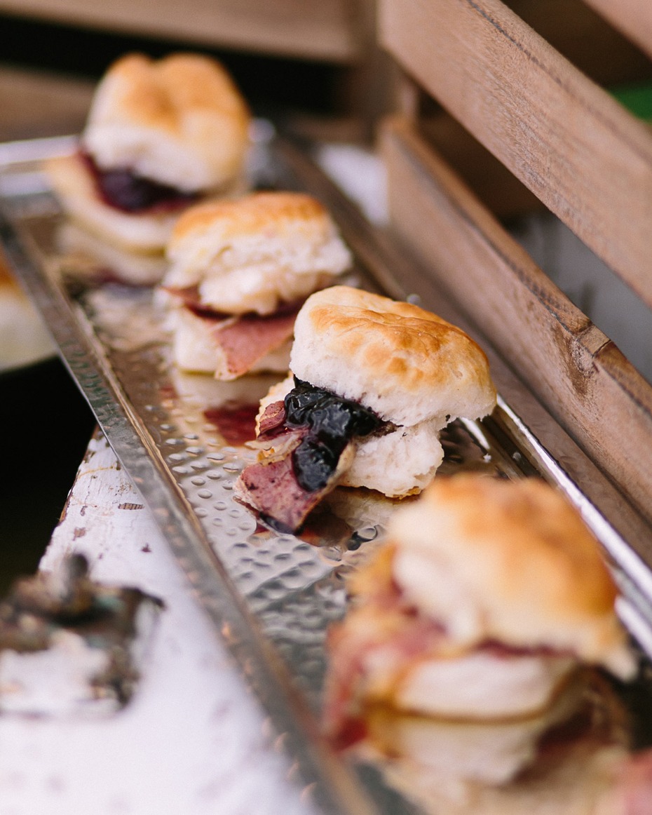 Mini biscuit sandwiches with meat and jam on silver tray
