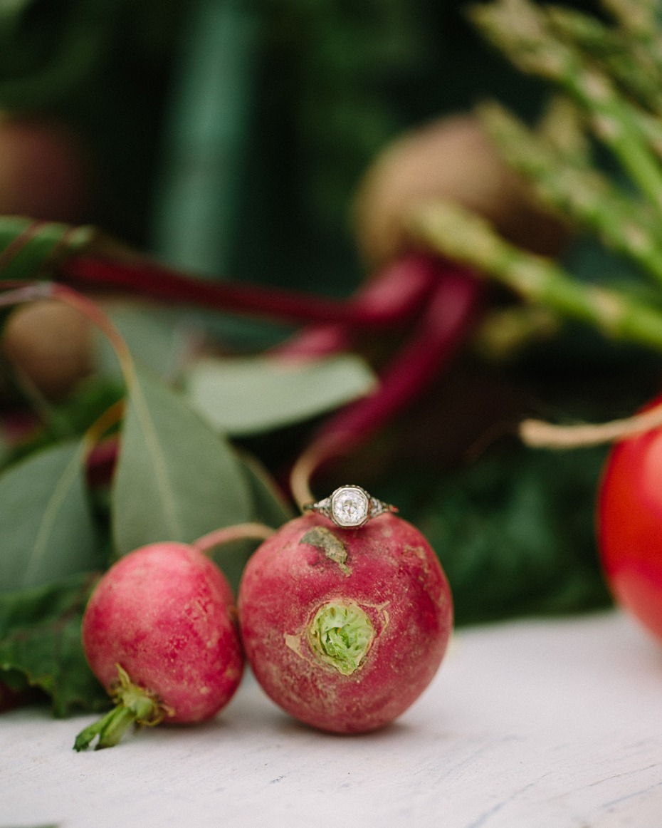 Engagement ring on a radish among garden vegetables